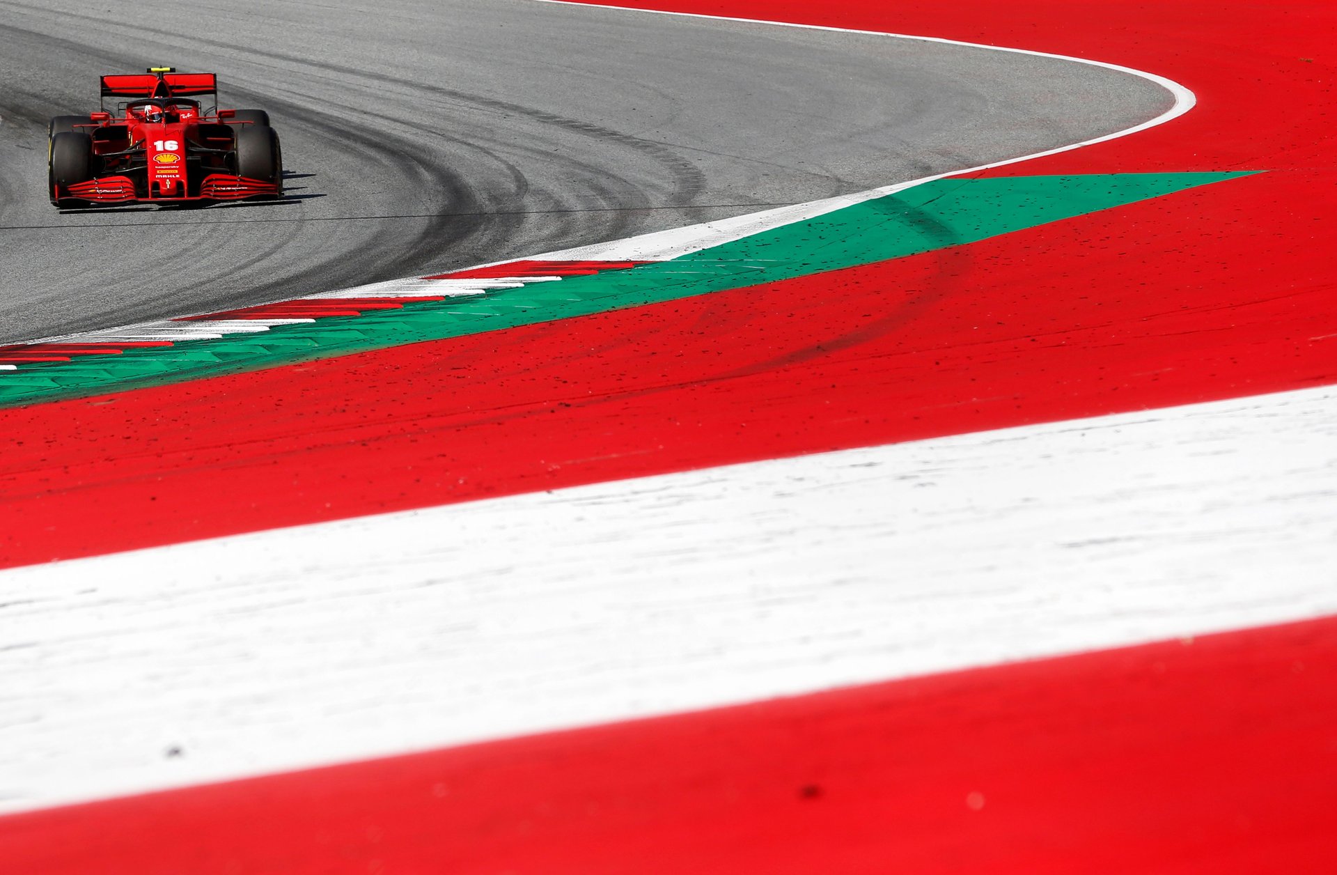 Ferarri team race car on a red and white painted track
