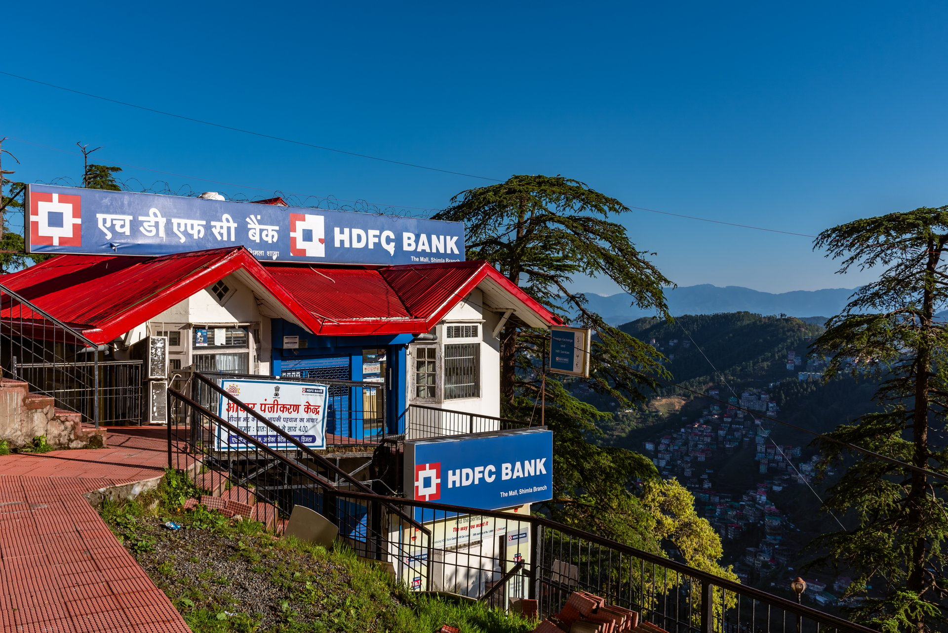 A branch of HDFC Bank sitting in the side of a green valley.