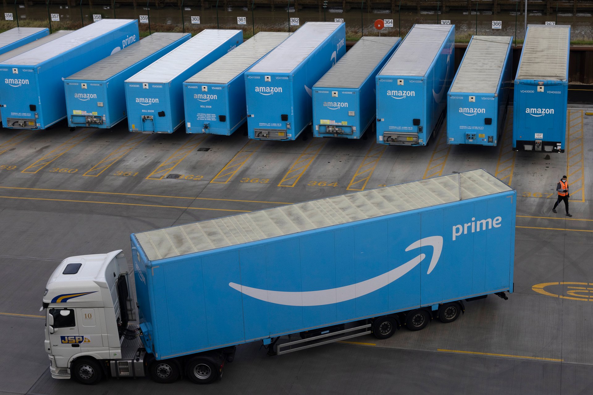  Amazon Prime lorries are seen at the Amazon fulfilment centre with one driving away.