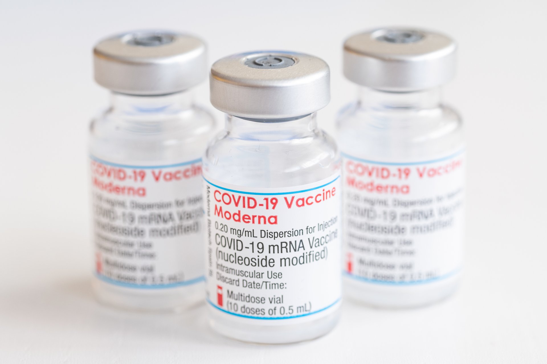 Three glass vaccine vials labelled COVID-19 Vaccine Moderna.