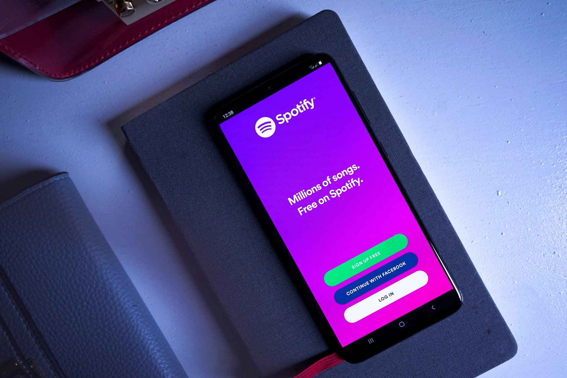 Mobile phone on a table with the Spotify app open on the login screen.