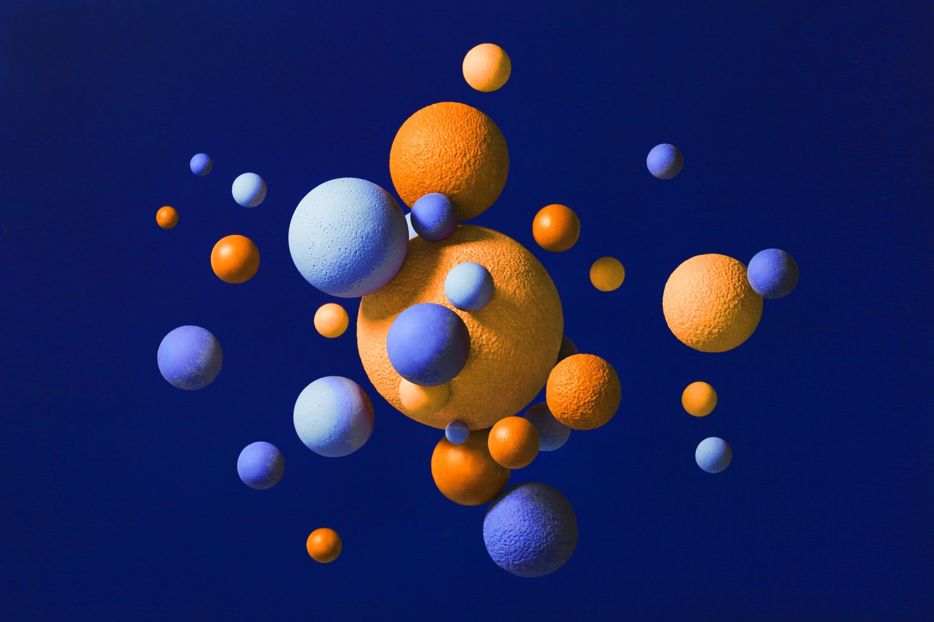 Abstract multi-colored spheres on blue background.
