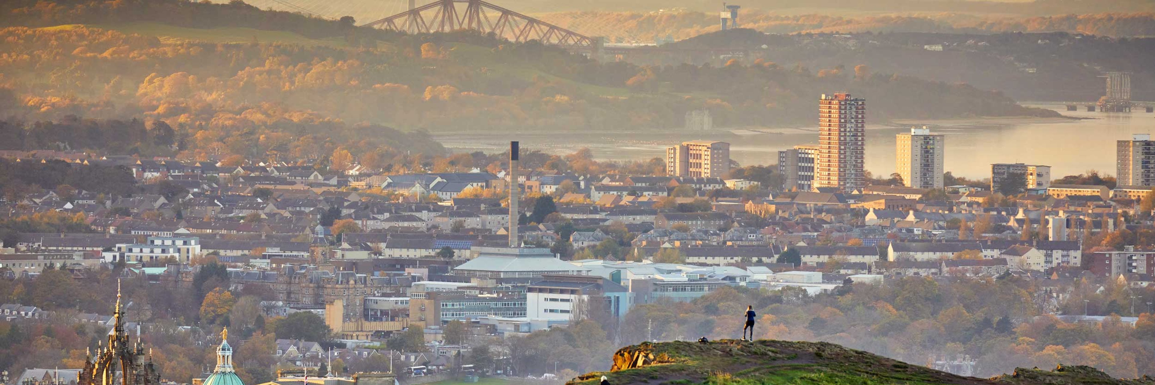 Edinburgh cityscape and skyline with Firth of Forth at sunset from Holyrood Park.
