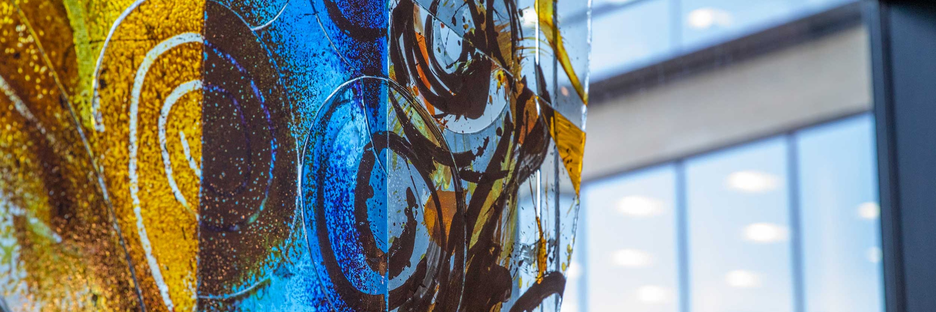 A close up of a marbled stain glass window with orange and blue colours.