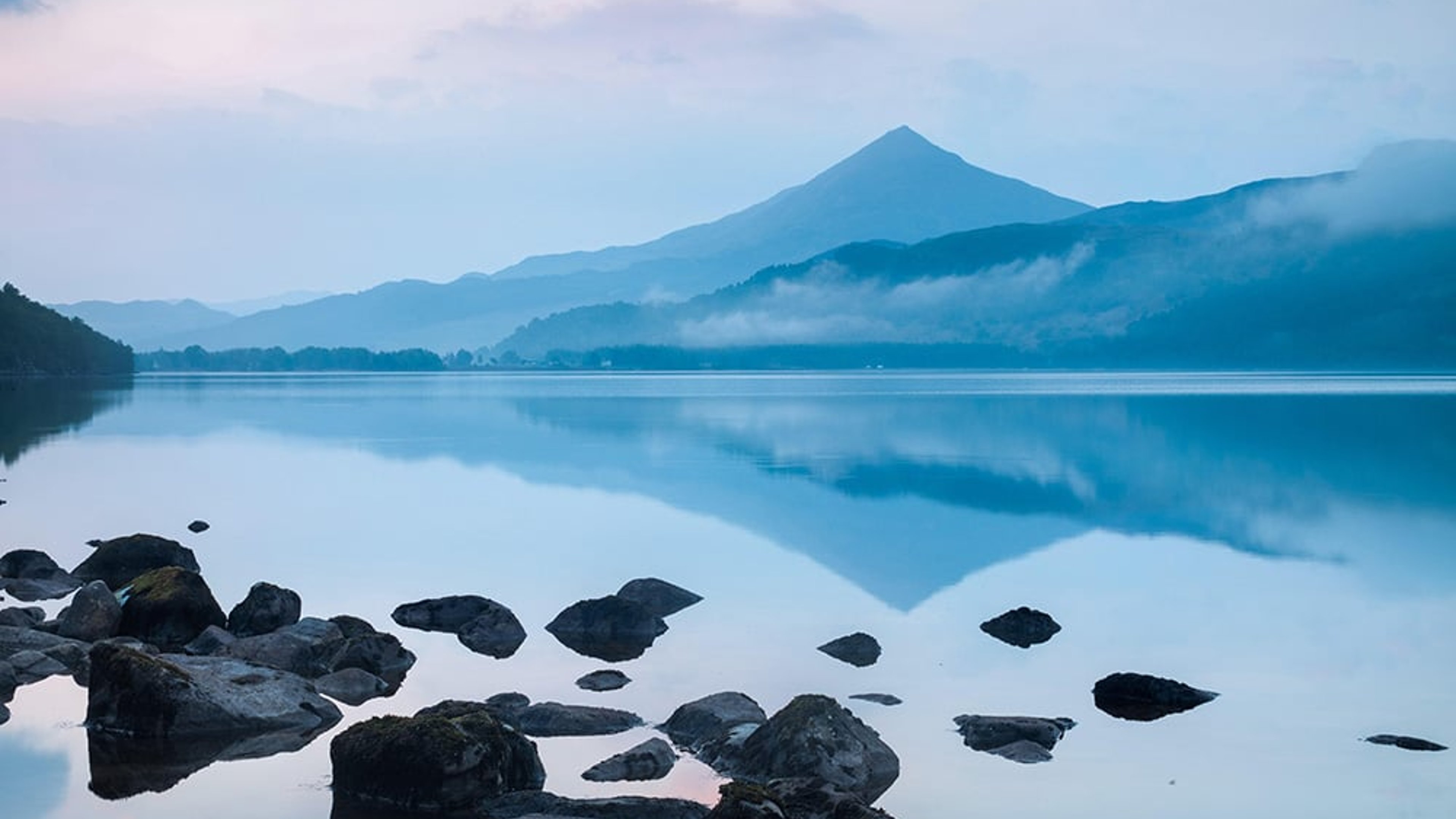 Schiehallion mountain reflected in calm Loch Rannoch waters at dawn, Perthshire, Scotland