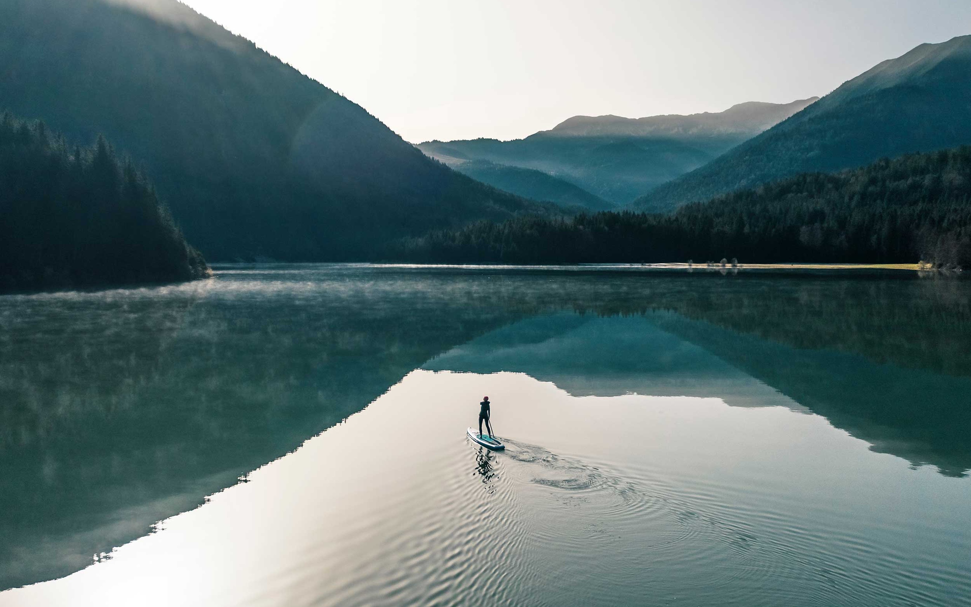 Woman paddleboarding on Sylvenstein lake, Germany.