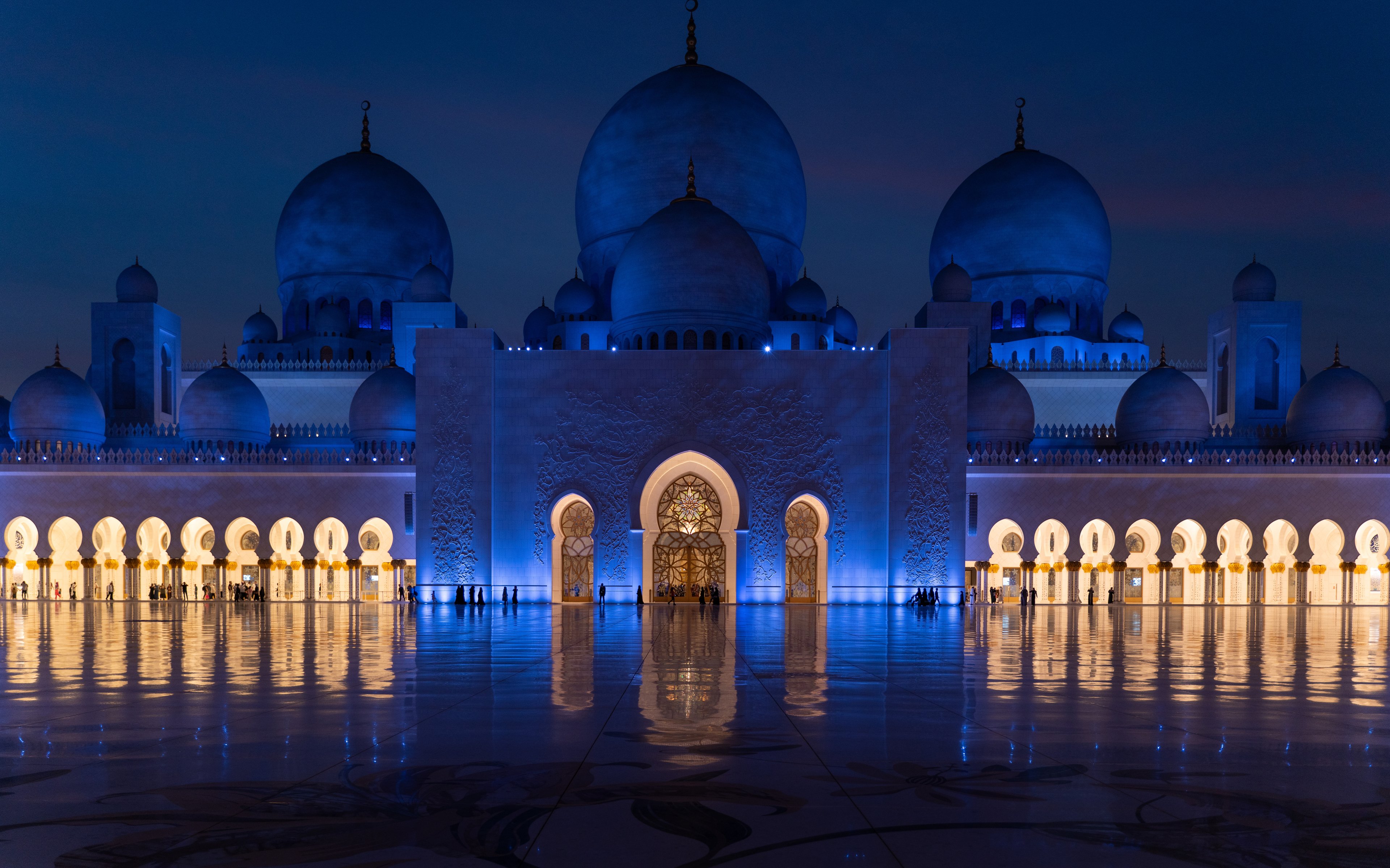 A dark night with a brightly lit Mosque surrounded by water