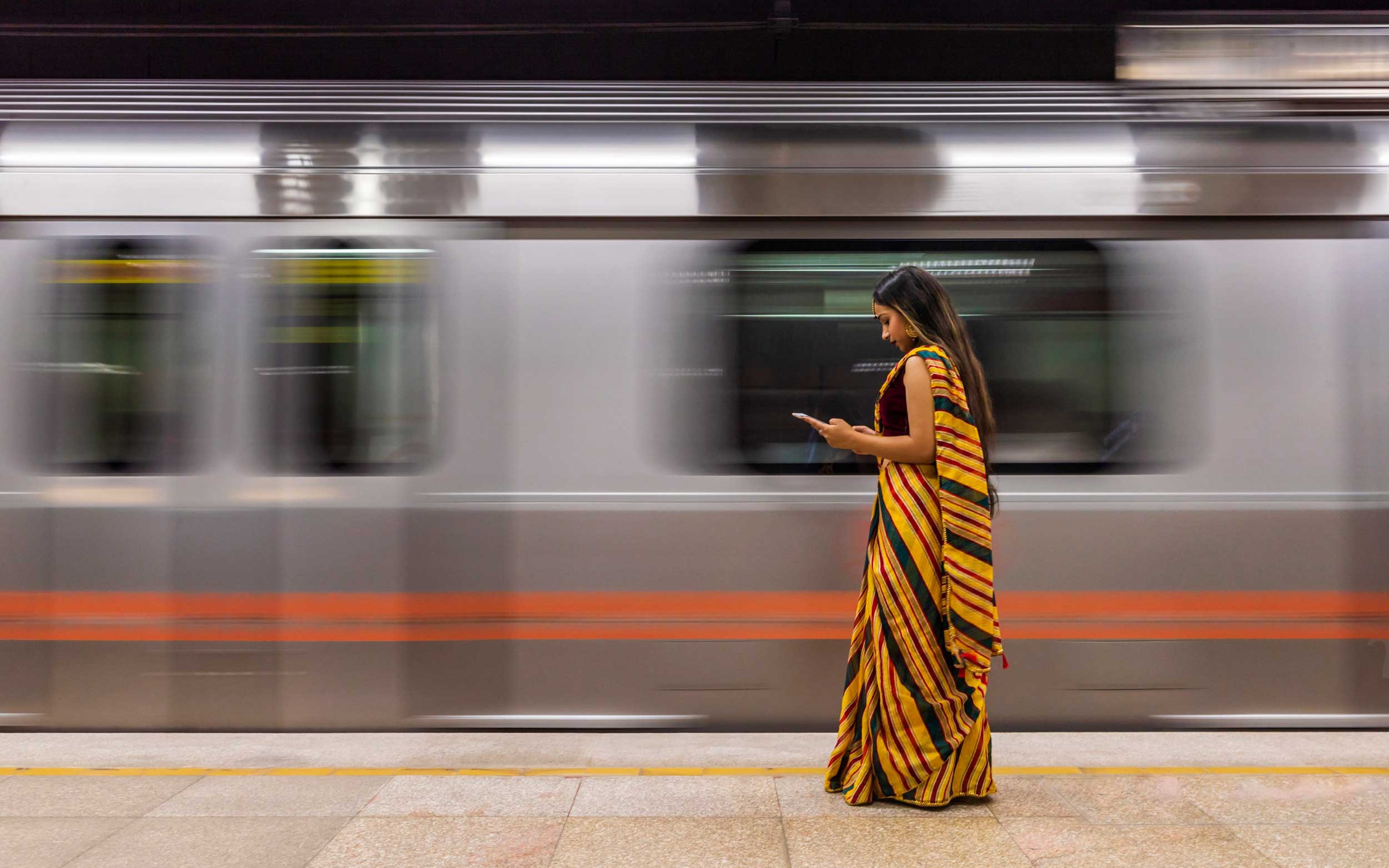 Young Indian woman waiting for a train at subway station in India.