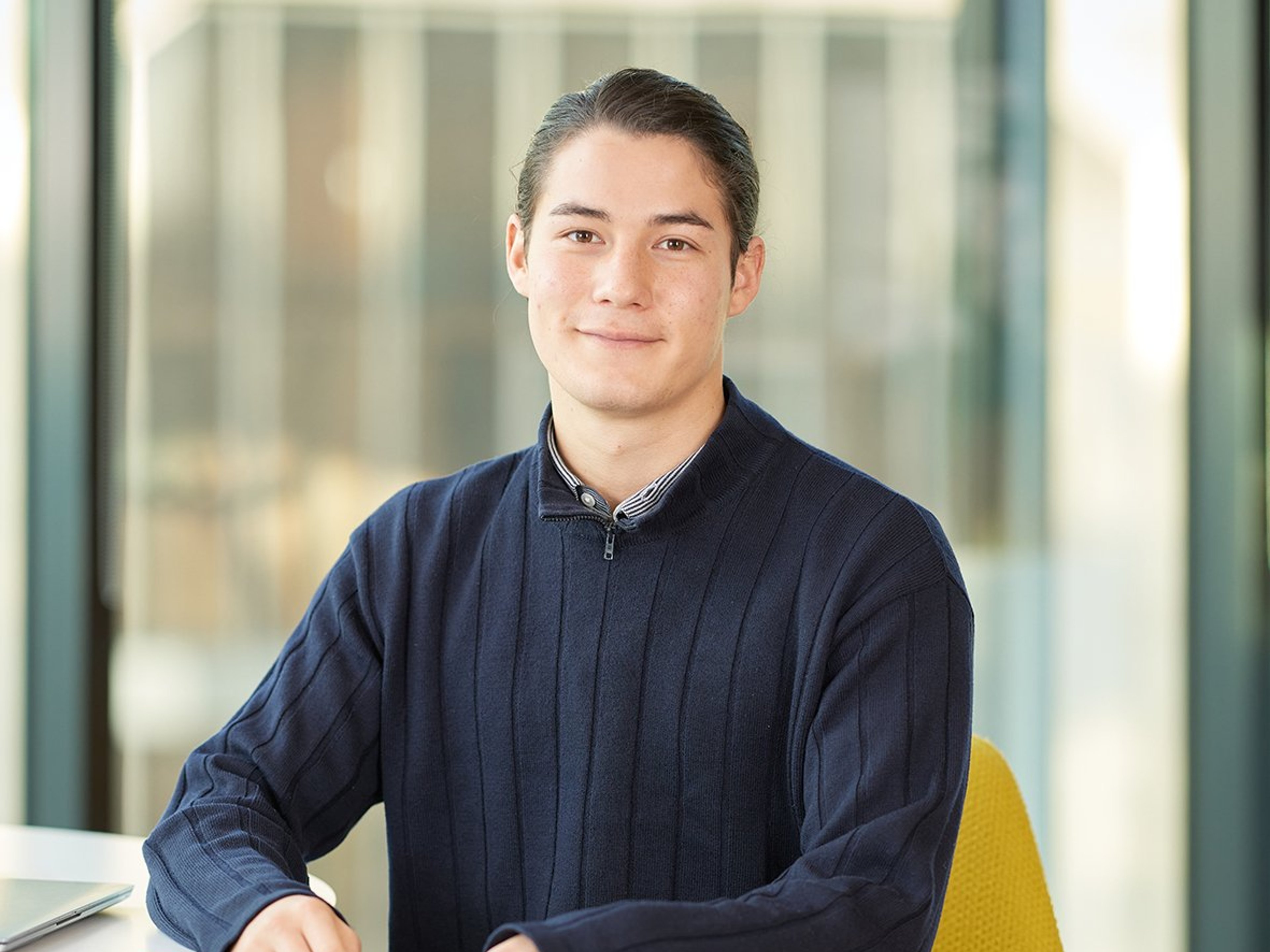 Kitsu Egerton sitting while leaning against a table.