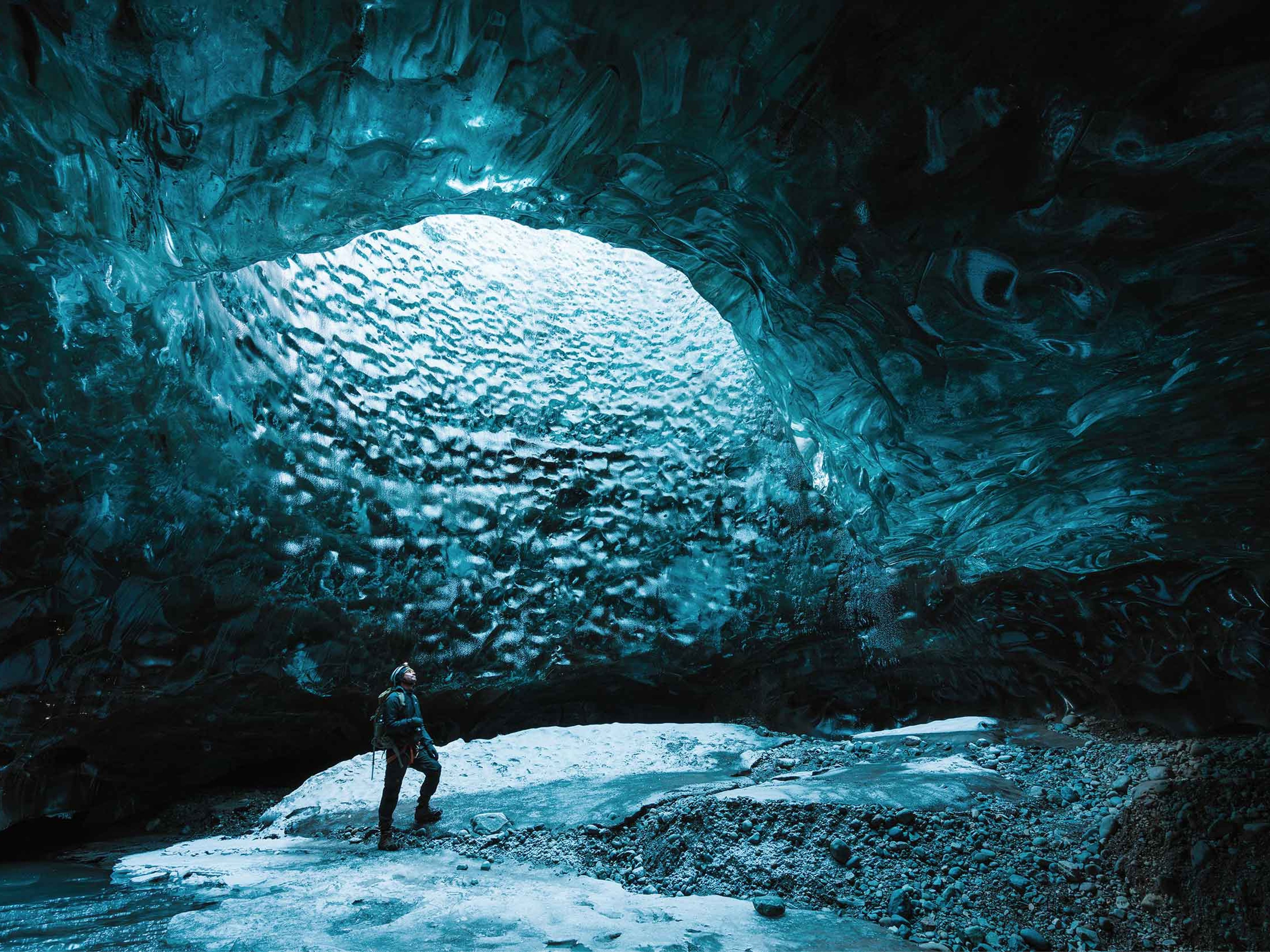 One man exploring beautiful Ice cave close to Jokulsarlon Glacier Lagoon.
