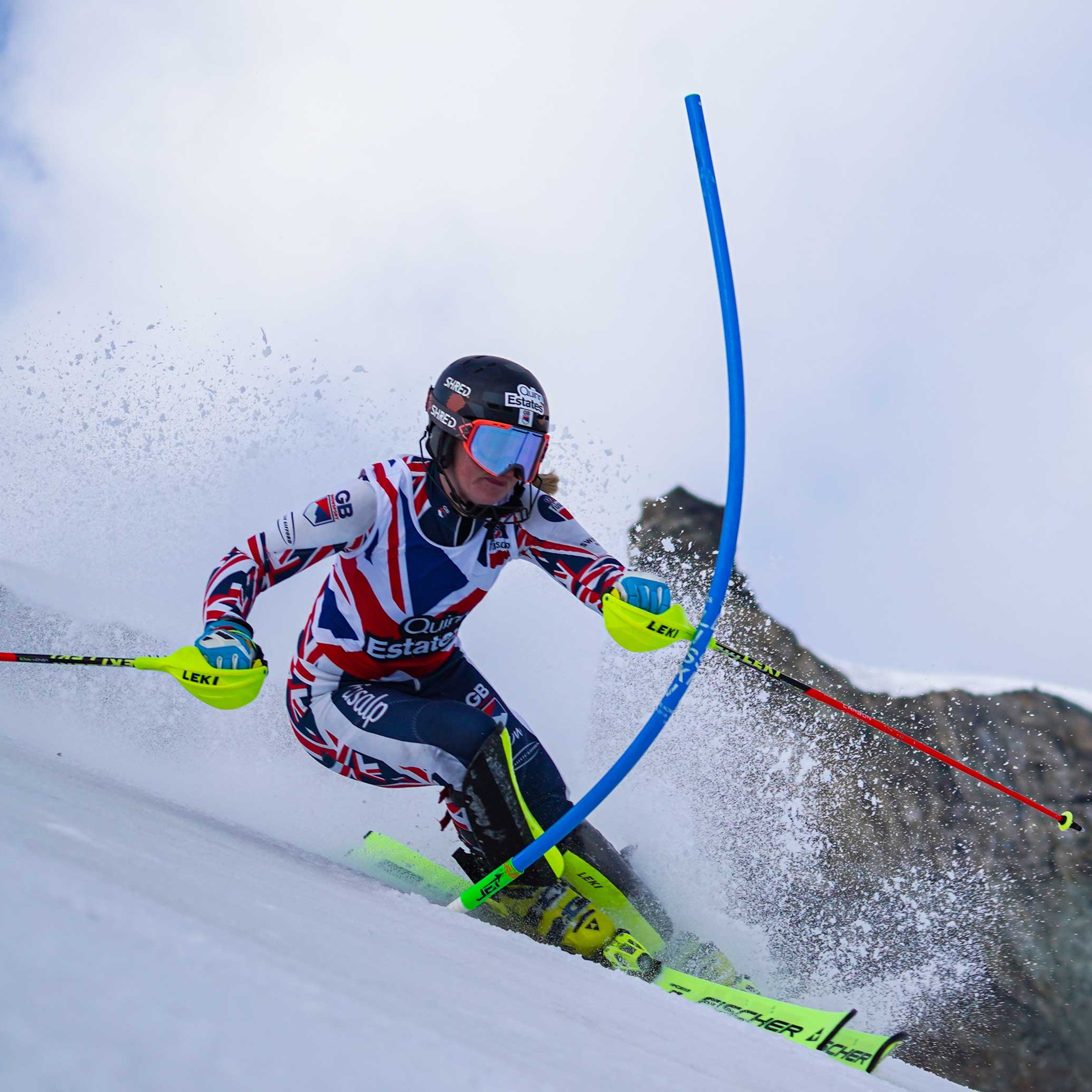 Charlie Guest skiing downhill through a slalom gate.