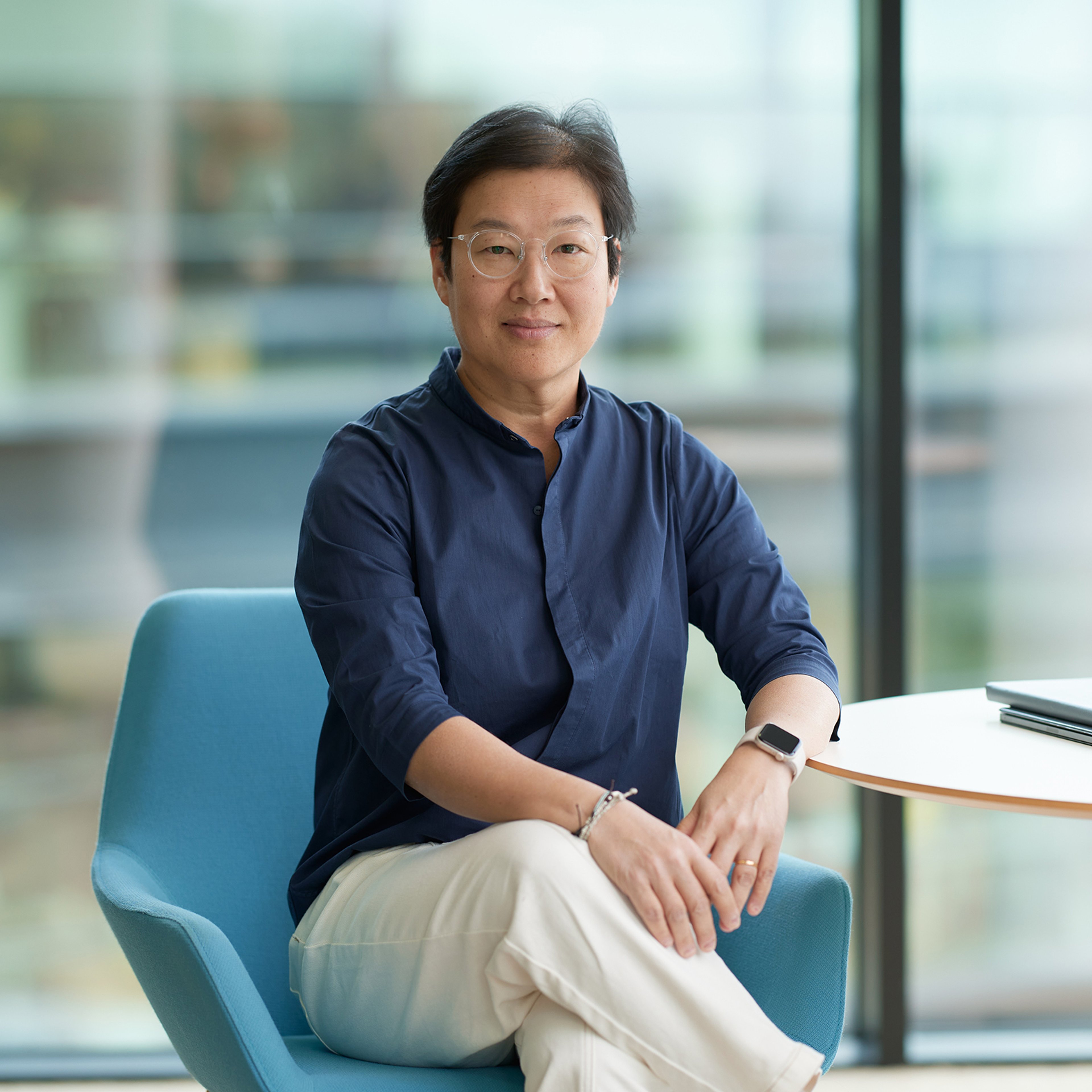 Jen Leong sitting while leaning against a desk.