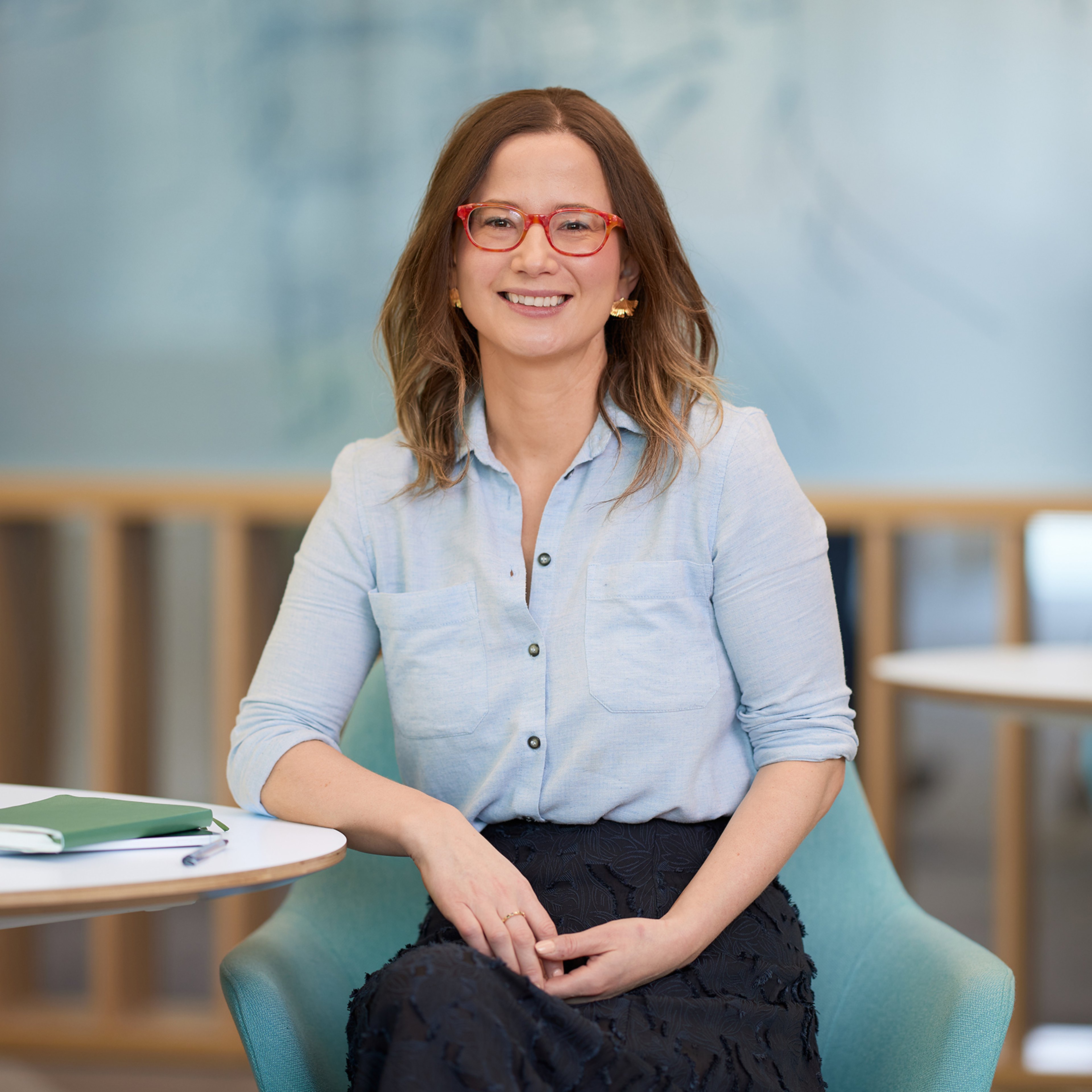 Aileen Lawless sitting while leaning against a table.