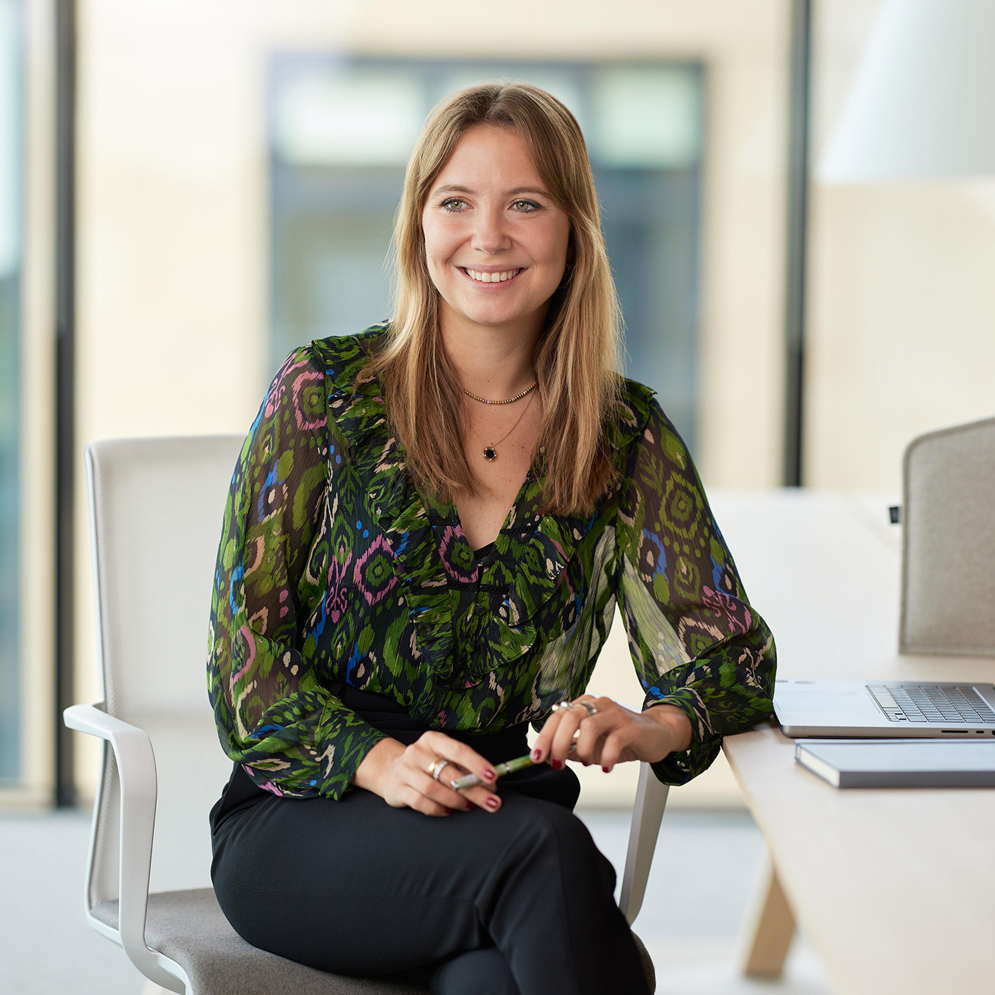 Silvia Conti sitting while leaning against a desk.