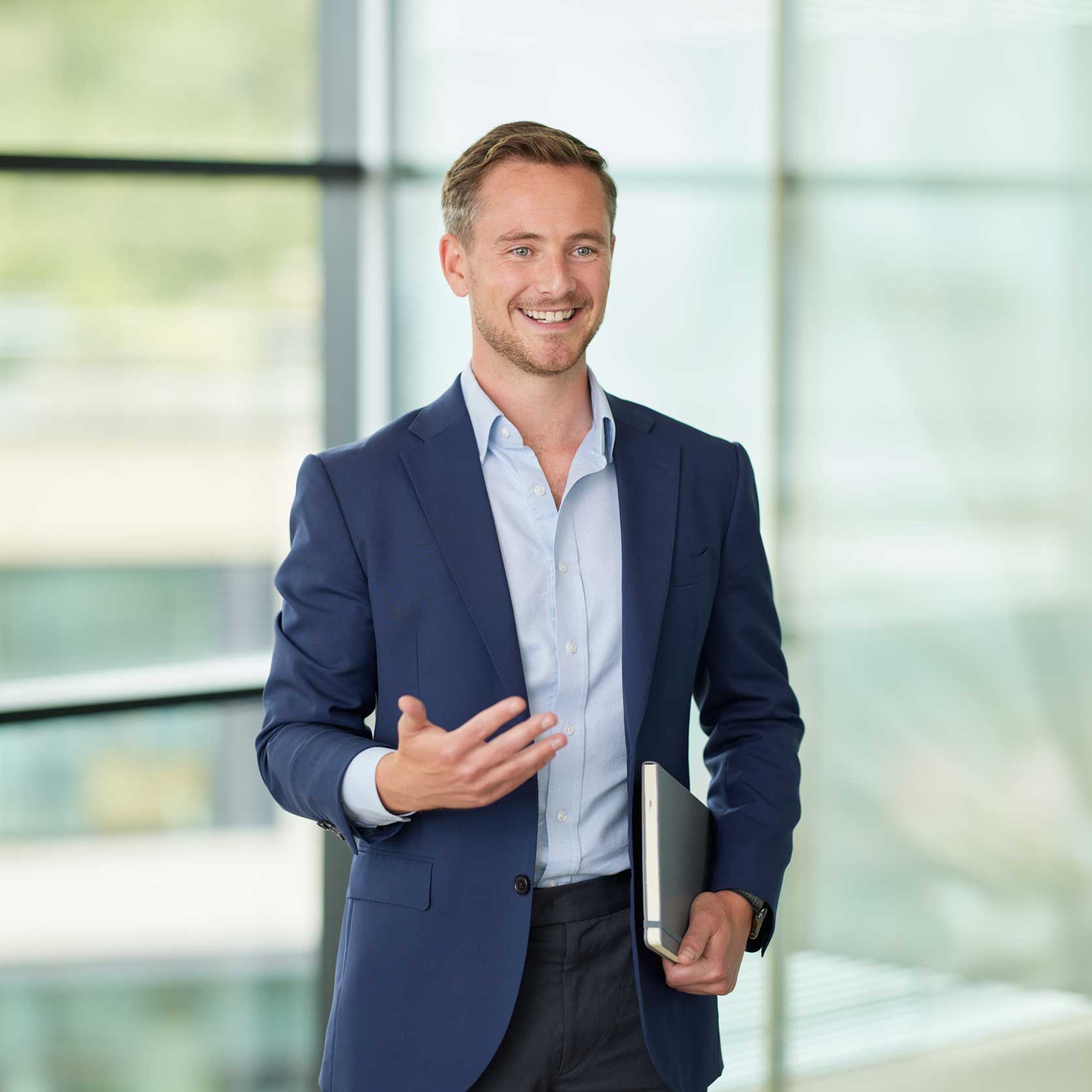 Jake Halliday standing while clutching a notepad.
