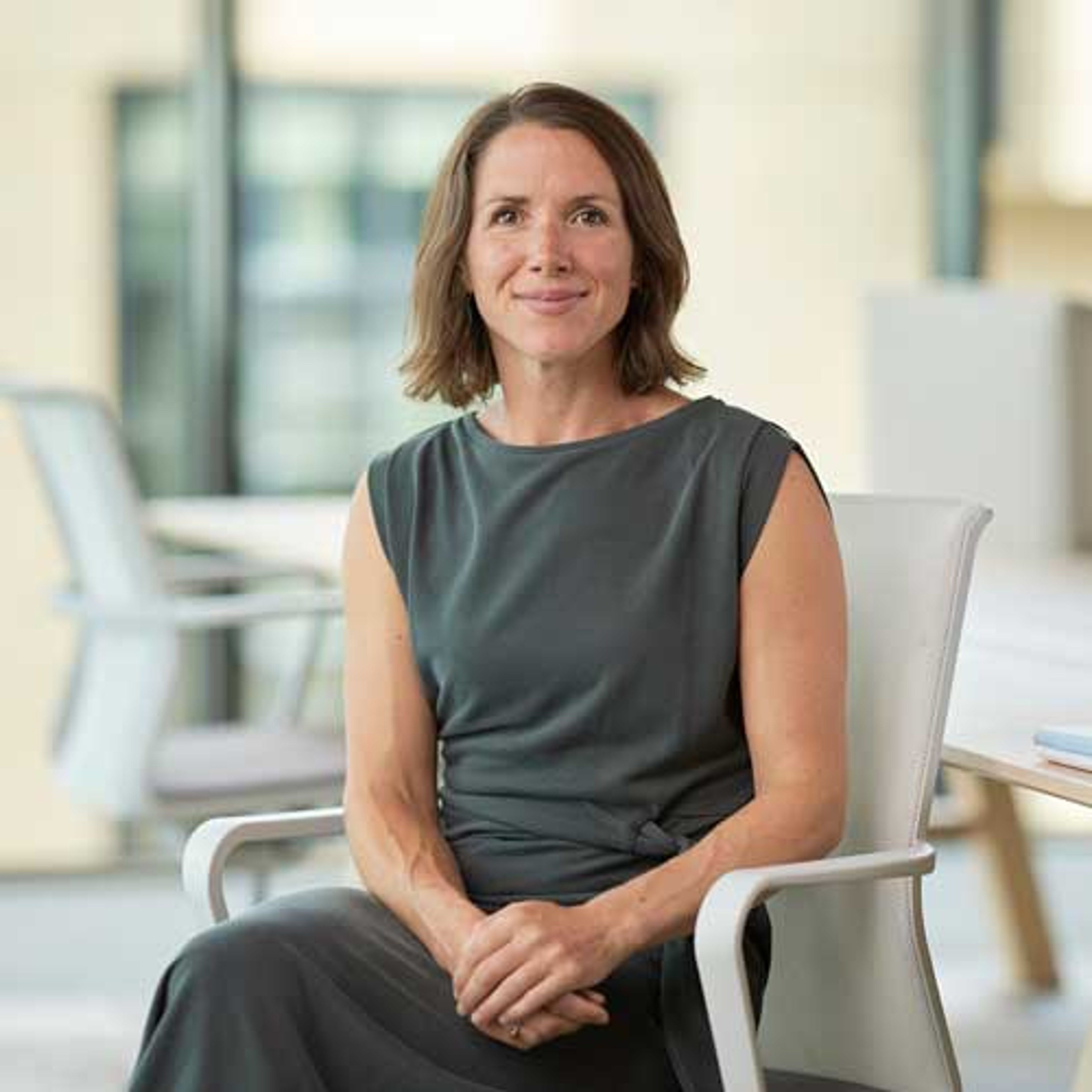 Susan Derbyshire sitting in the Baillie Gifford office with her hands clasped.