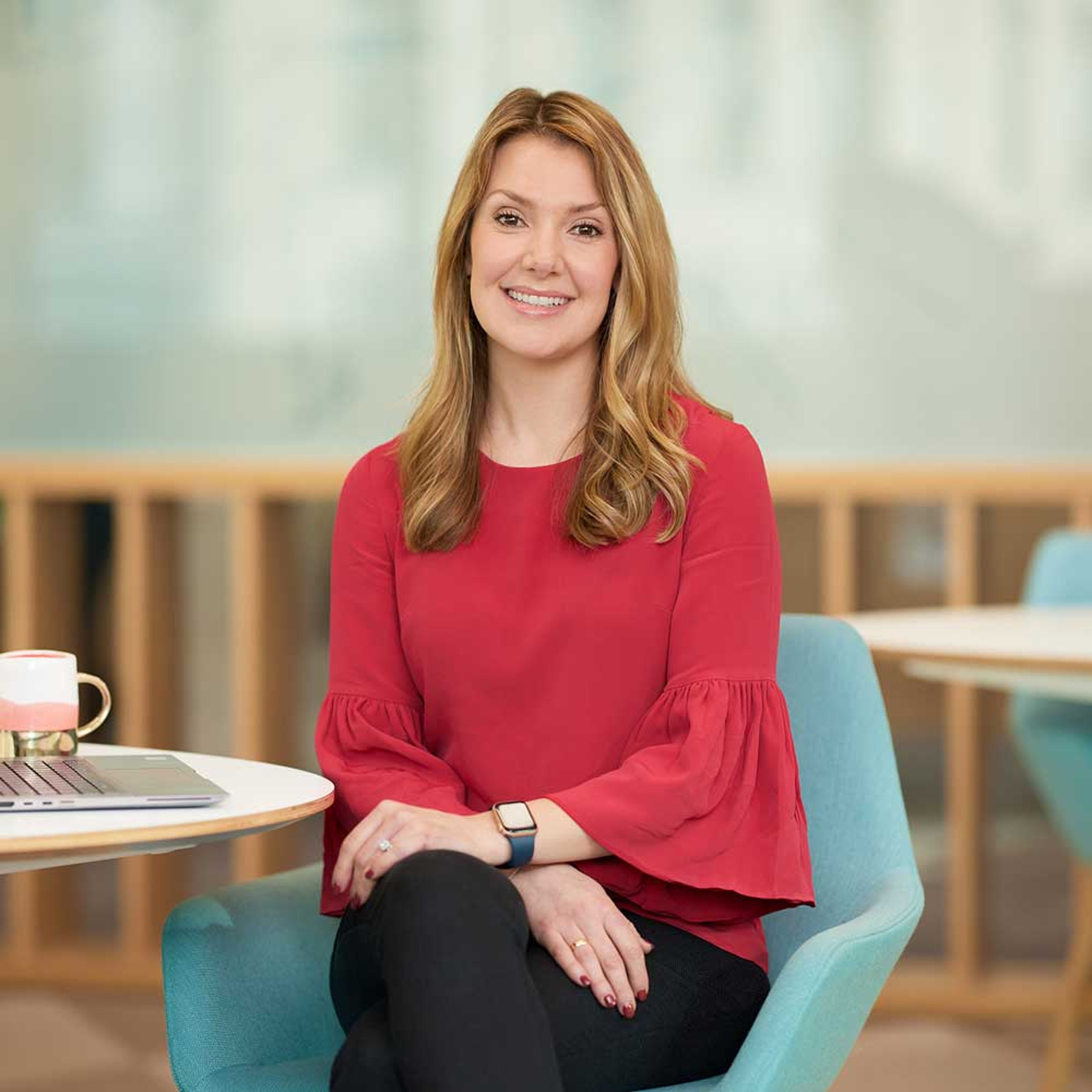 Helen Roxburgh setting at a desk with a notepad and mug on a desk next to her.