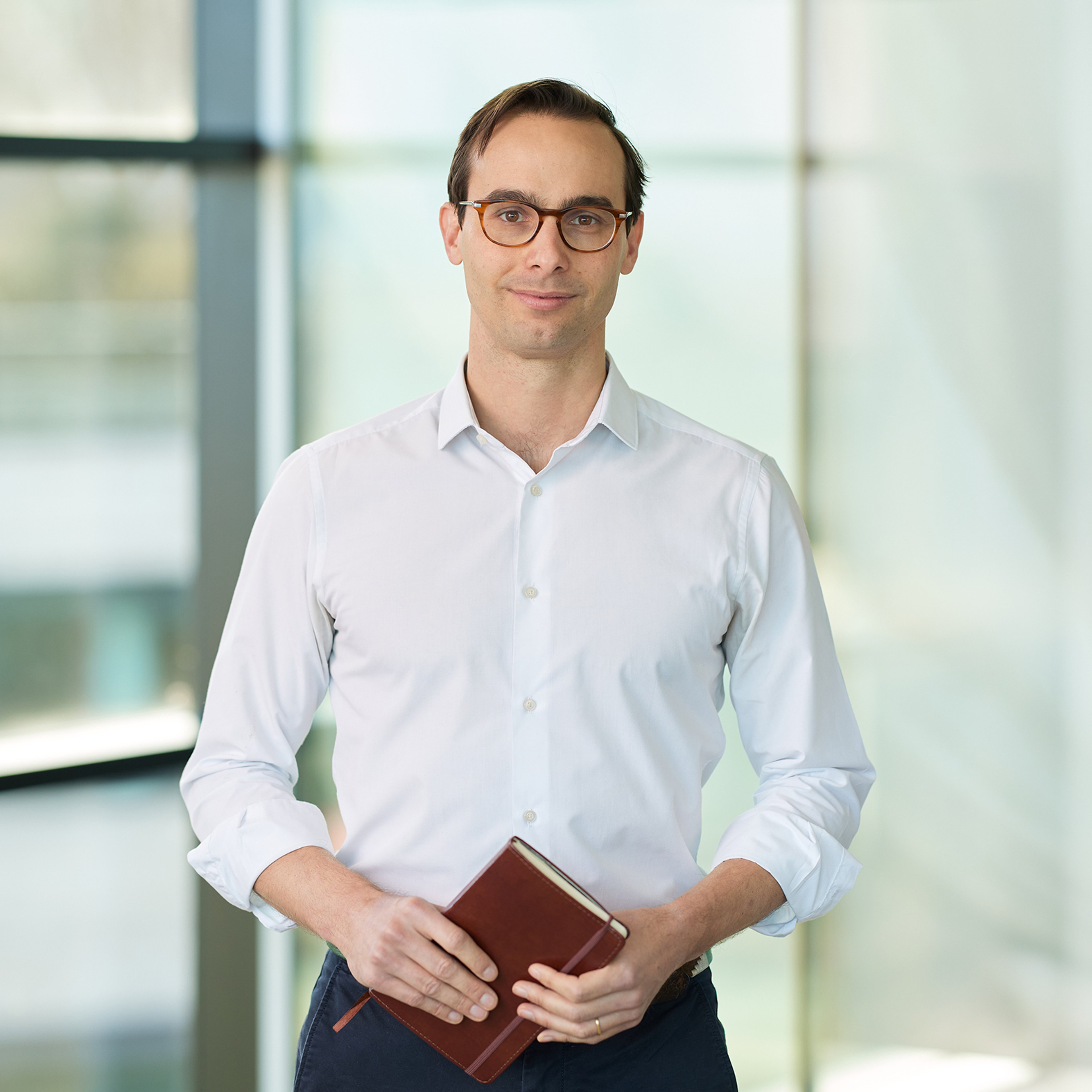 Andres Faia standing clutchinbg a notepad.