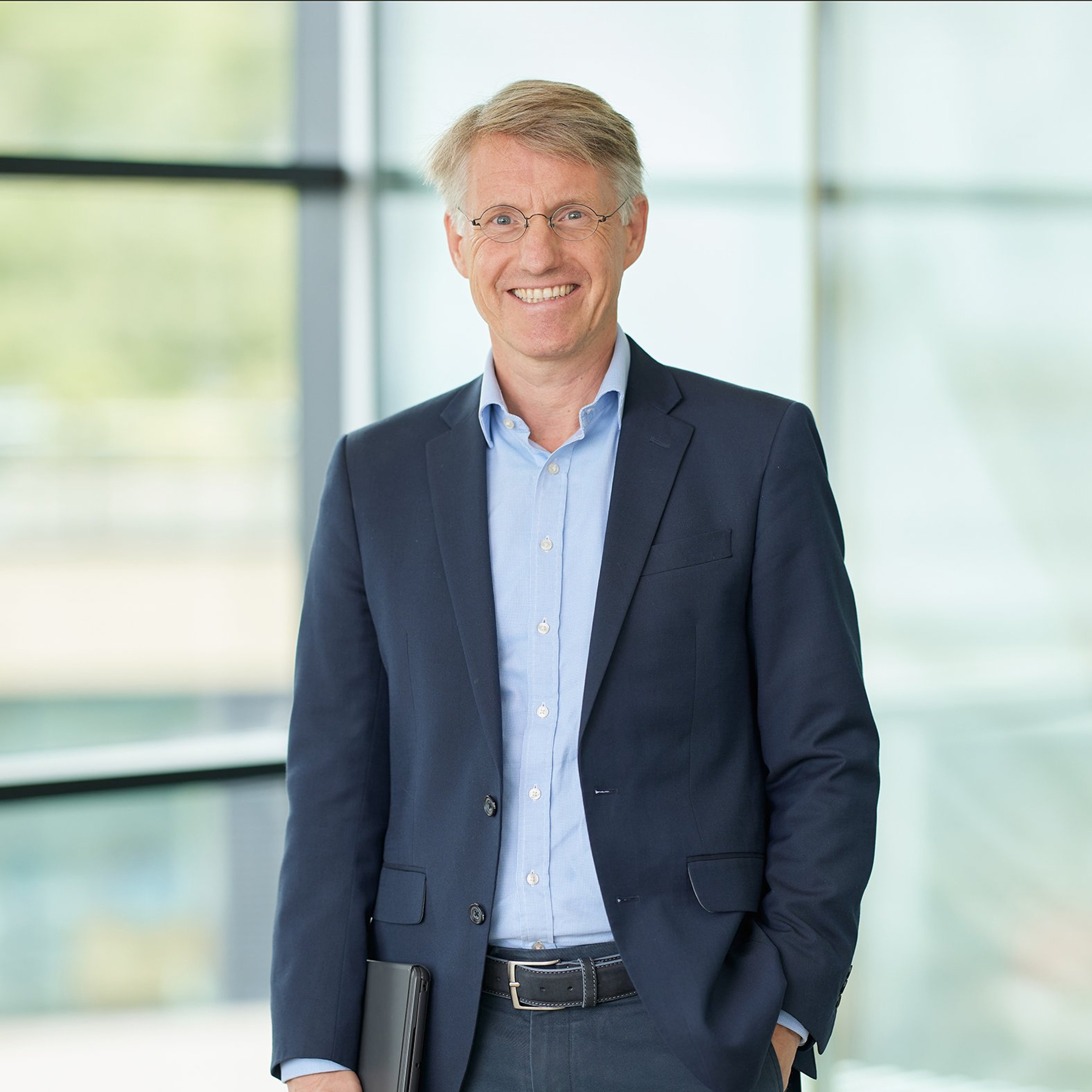 Wim de Ruijter standing while clutching a notepad.