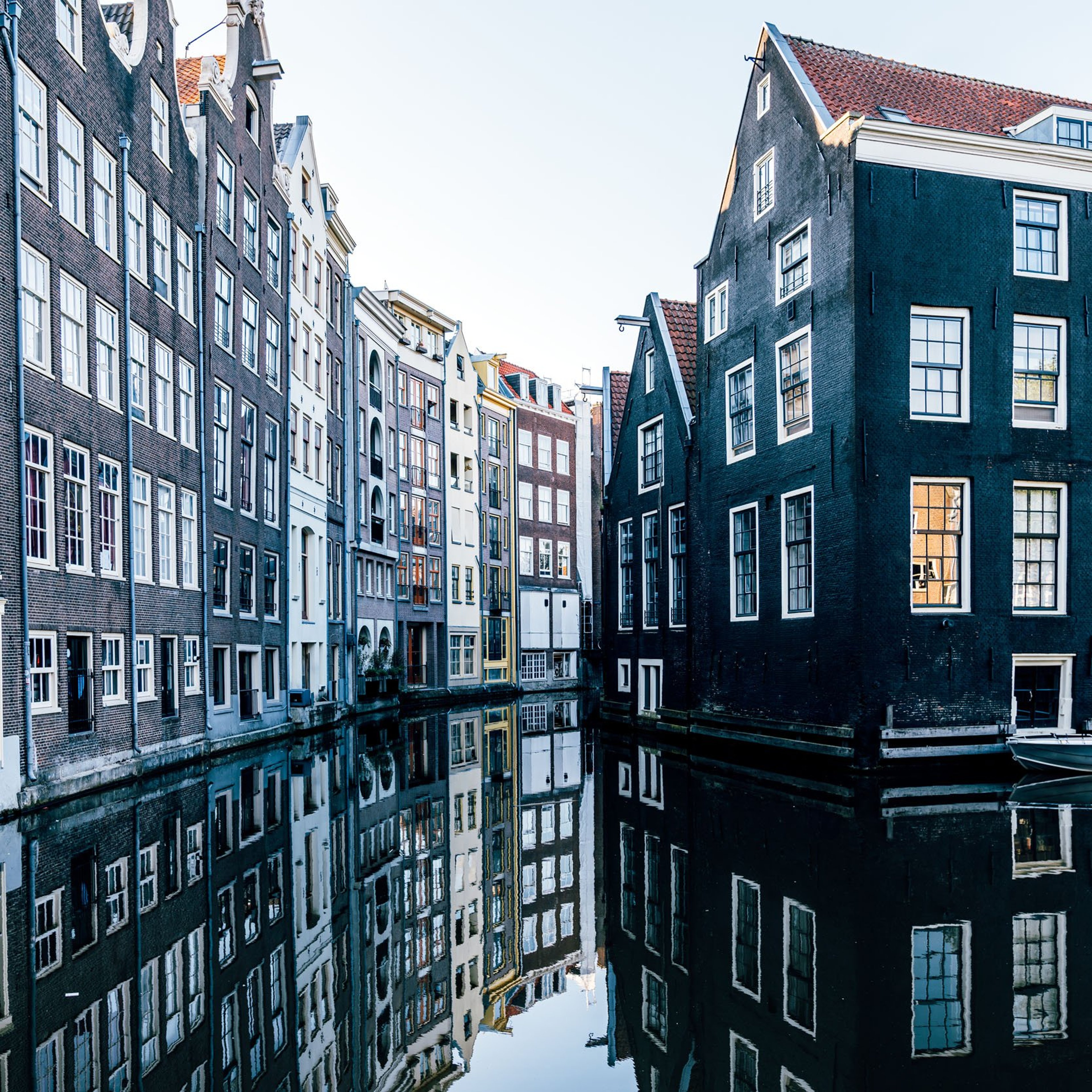 Traditional Dutch houses reflecting in the canal, Amsterdam, Netherlands.