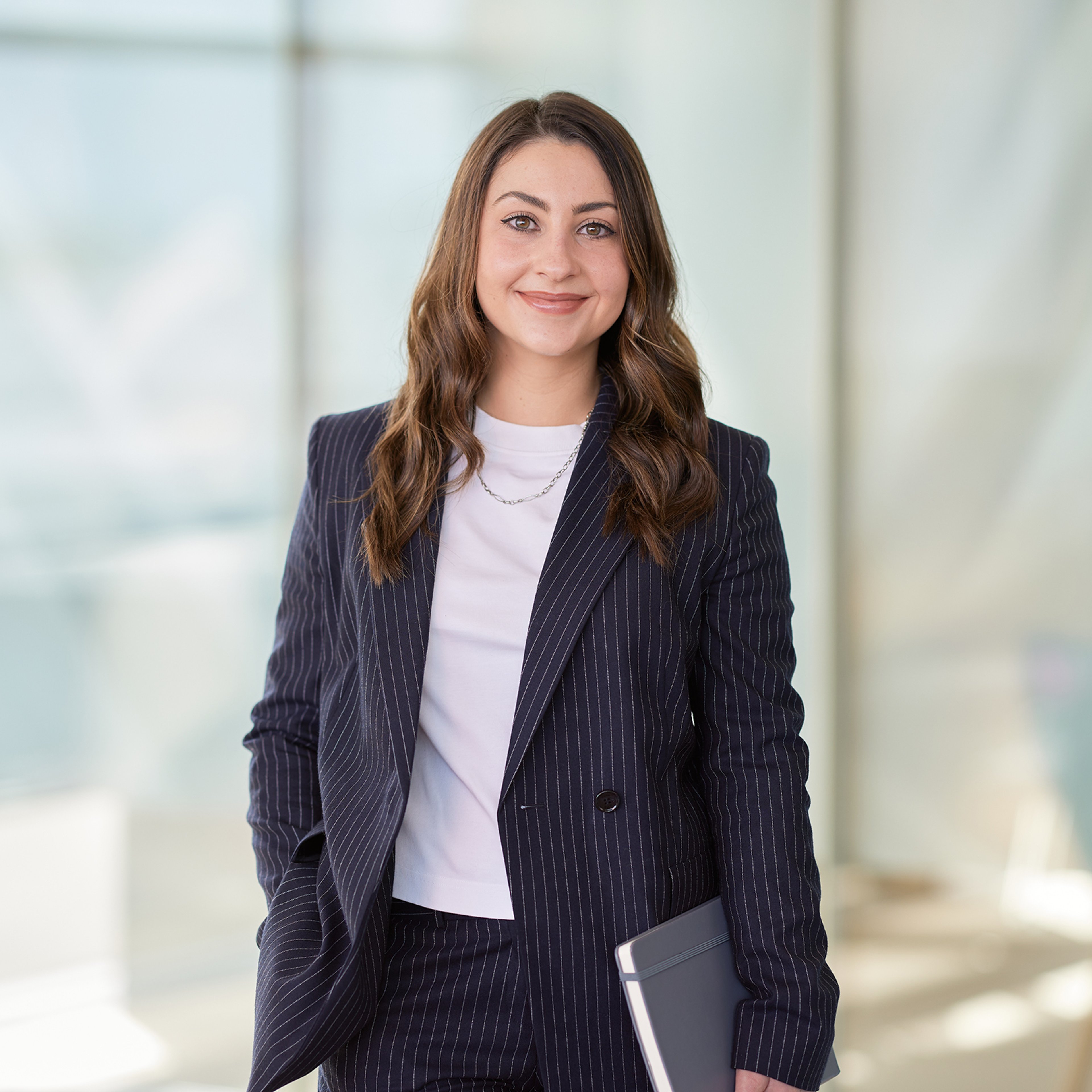 Megan Rooney standing clutching a notebook.