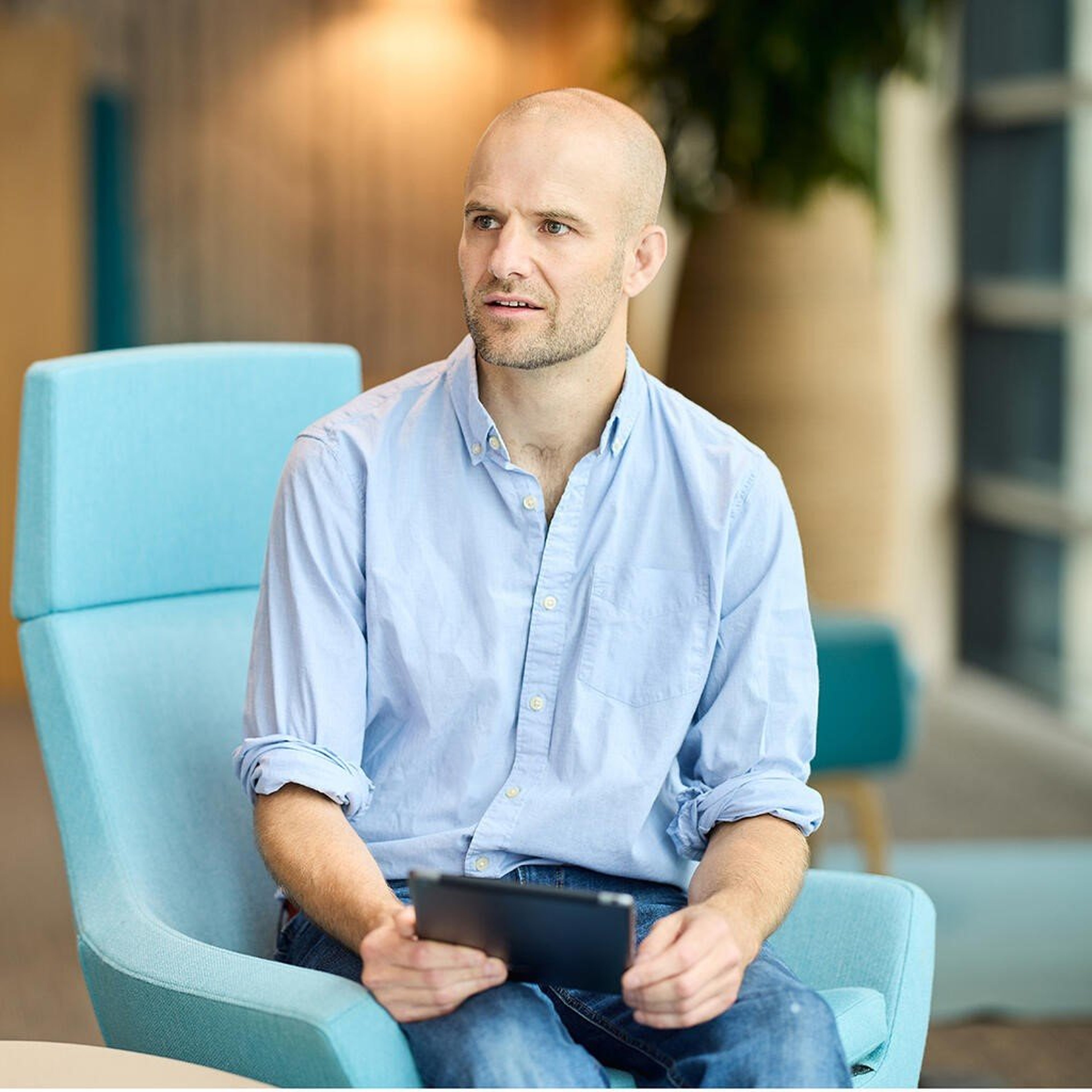 Andrew Daynes sat holding and iPad in the Baillie Gifford office.