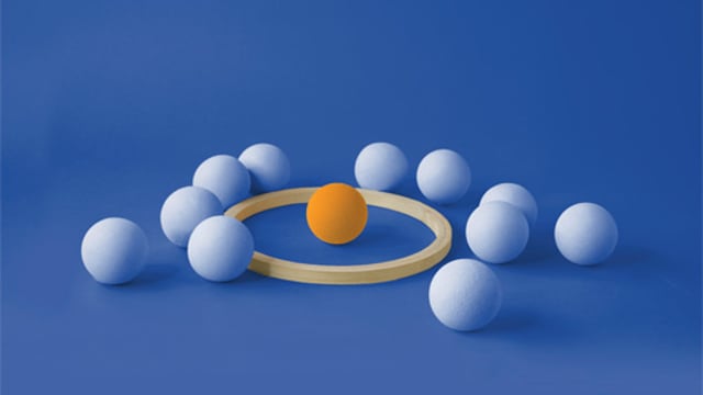 Abstract of blue spheres with one orange sphere inside a circle.